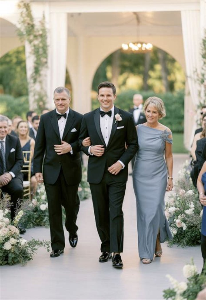 Does the groom walk down the aisle with his mother?