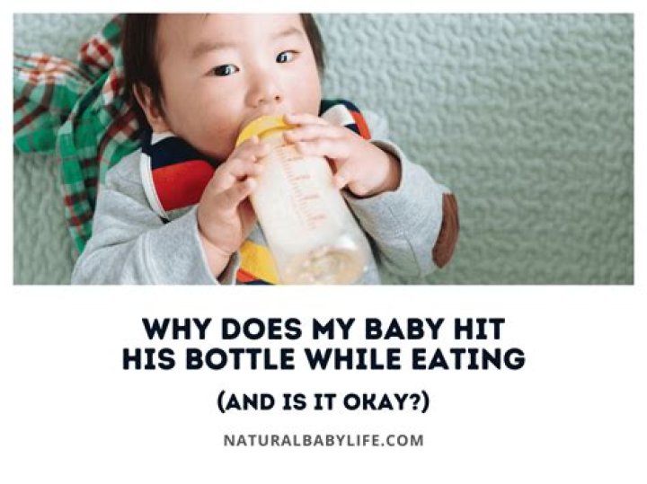 Why does my baby hit his head with his hand when feeding?