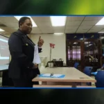 Ms Lawrence giving presenting the Students' Hand book at LCA Orientation day 2023